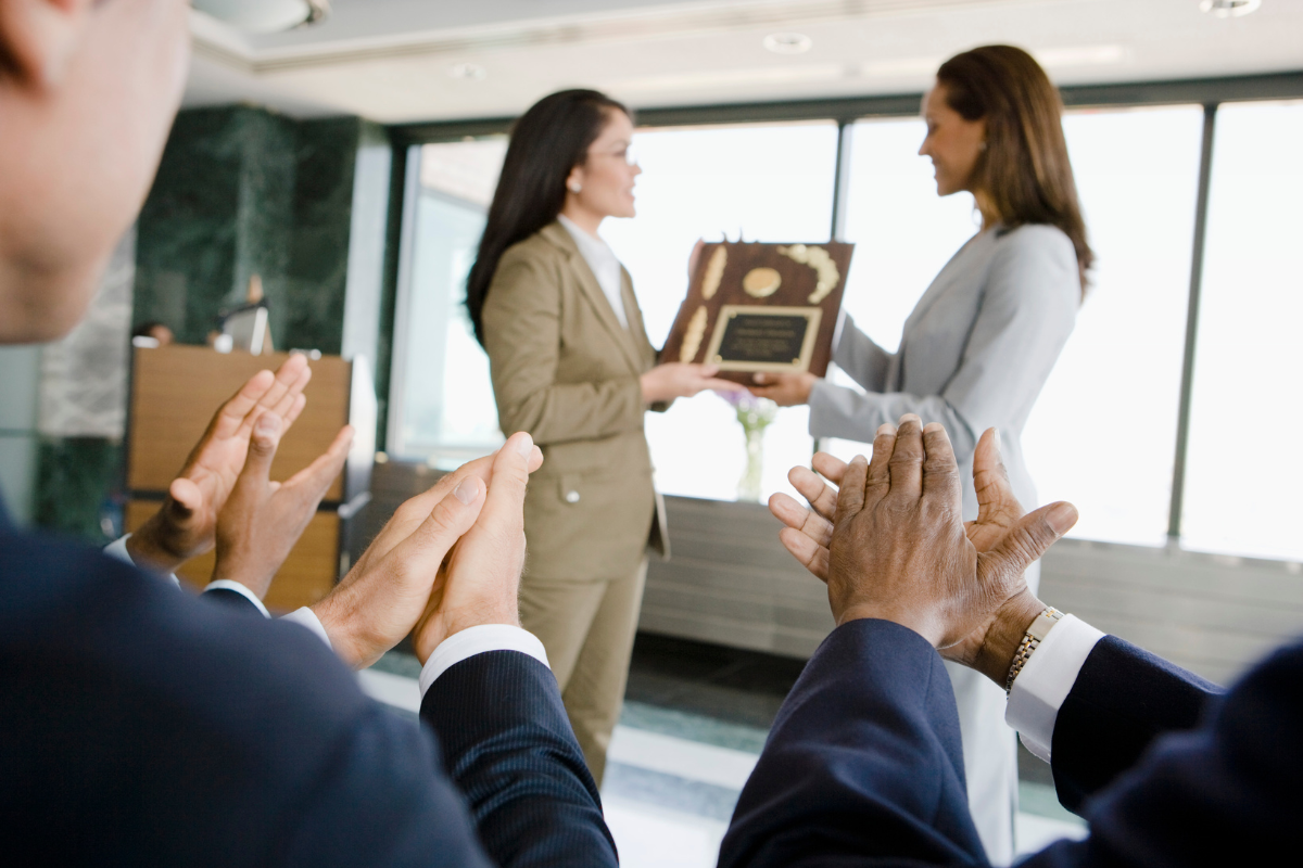 Woman presenting award with applause