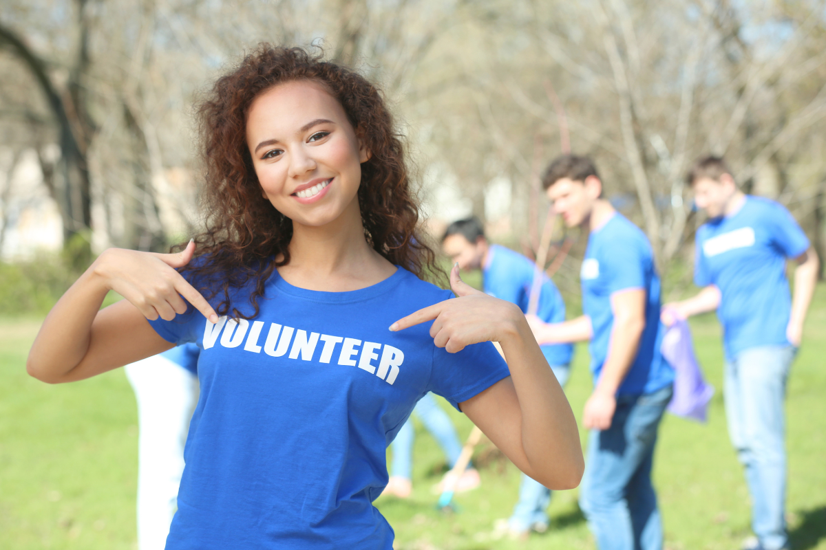 Woman wearing "Volunteer" shirt, other volunteers in the background