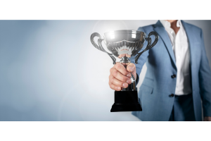 Businessperson holding trophy in hand