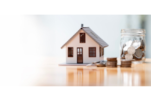 Model of house with coins and coin jar next to it