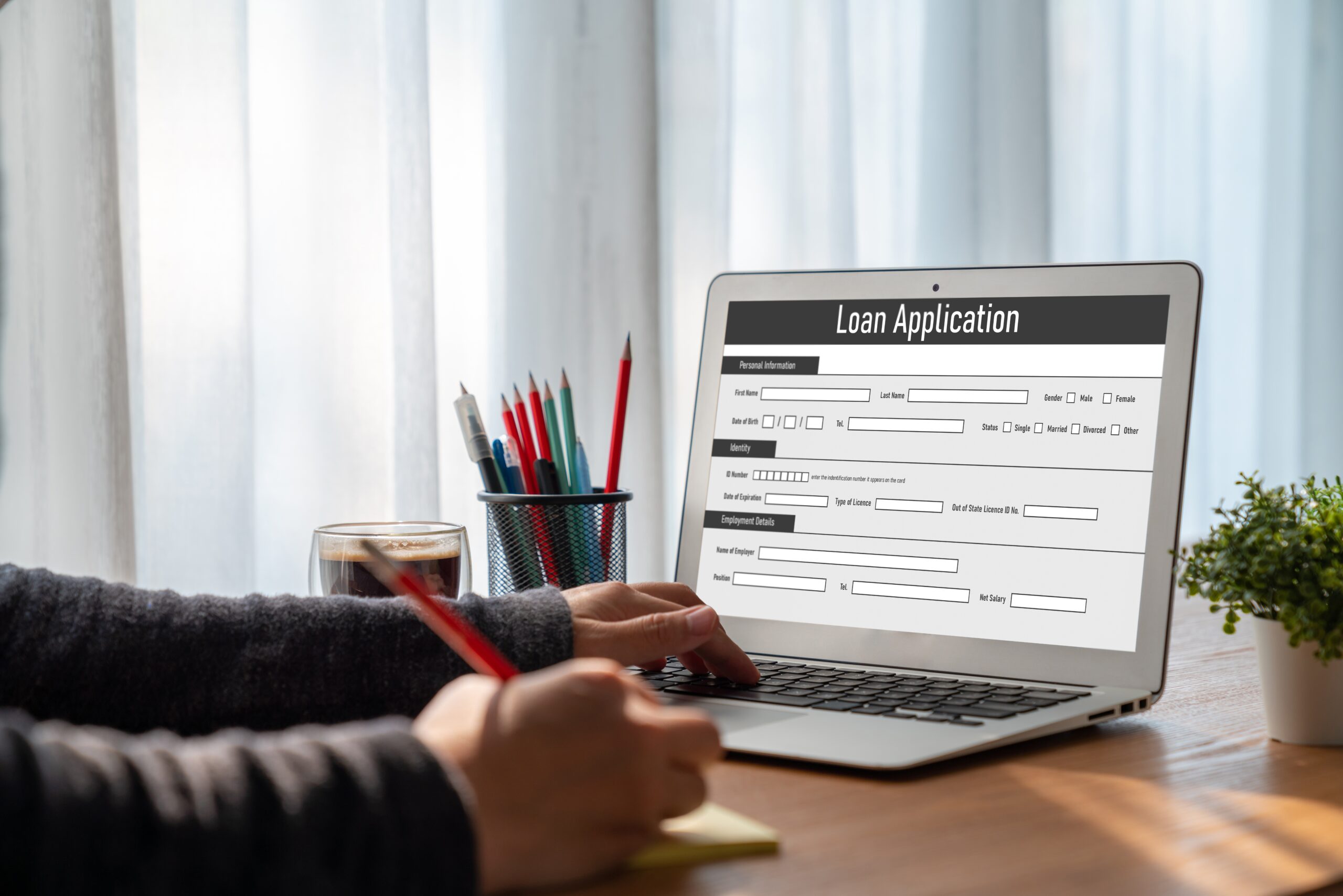 Person filling out online loan application on laptop