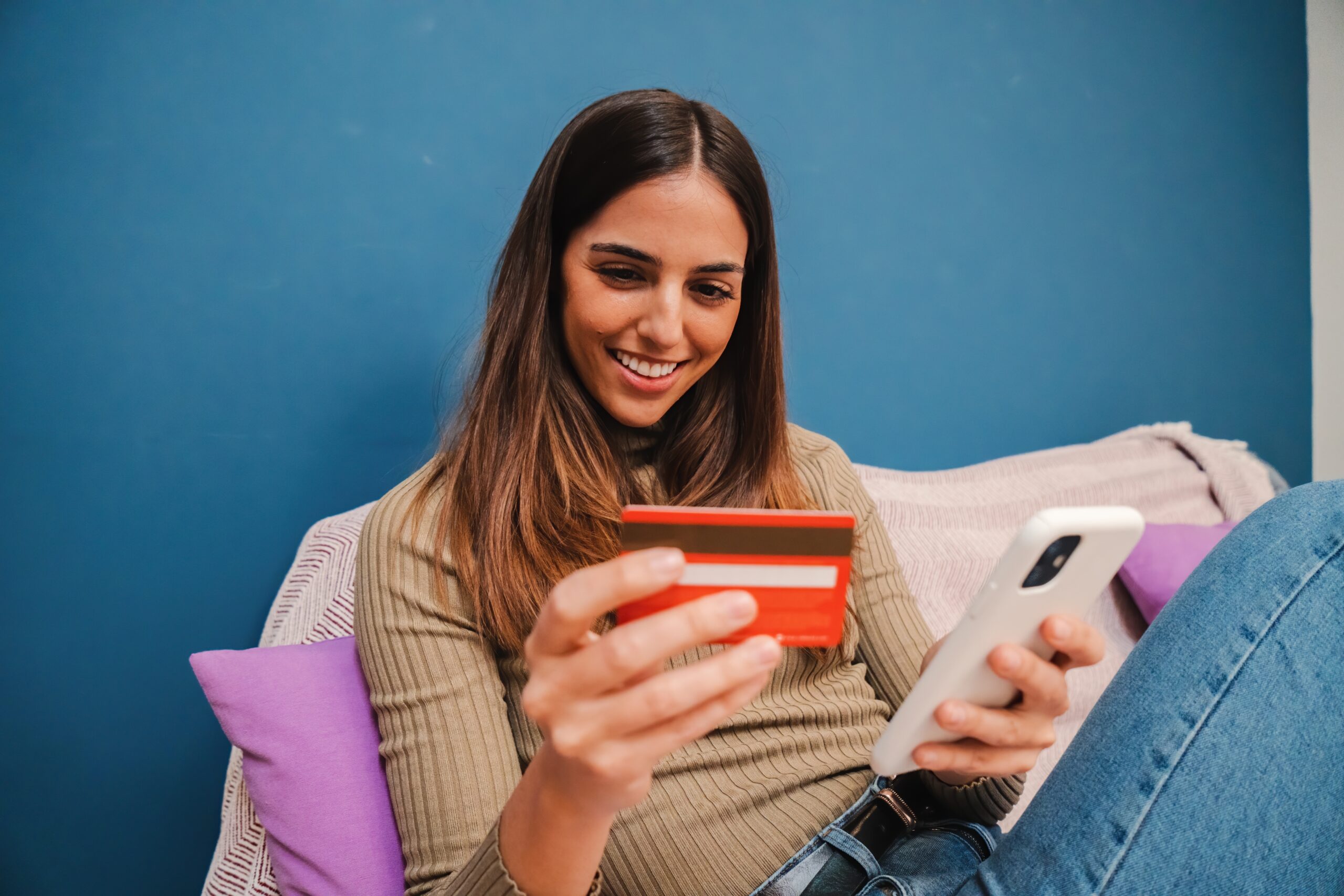 Woman holding credit card and smartphone