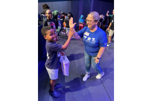 Jamie Vasquez with Texas Trust Credit Union helped a young student select a free pair of shoes at the Mansfield ISD back to school bash.