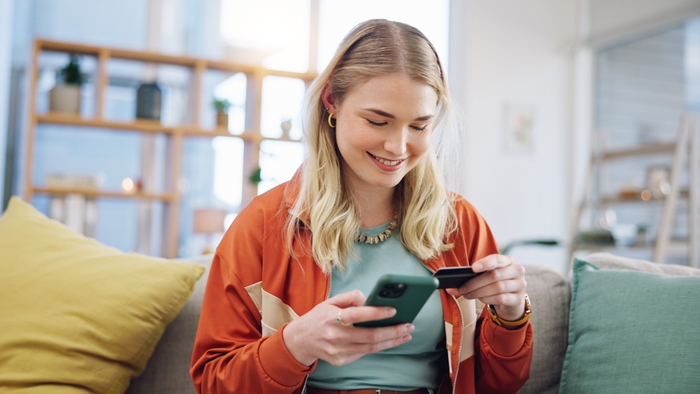 Woman holding smartphone and credit card