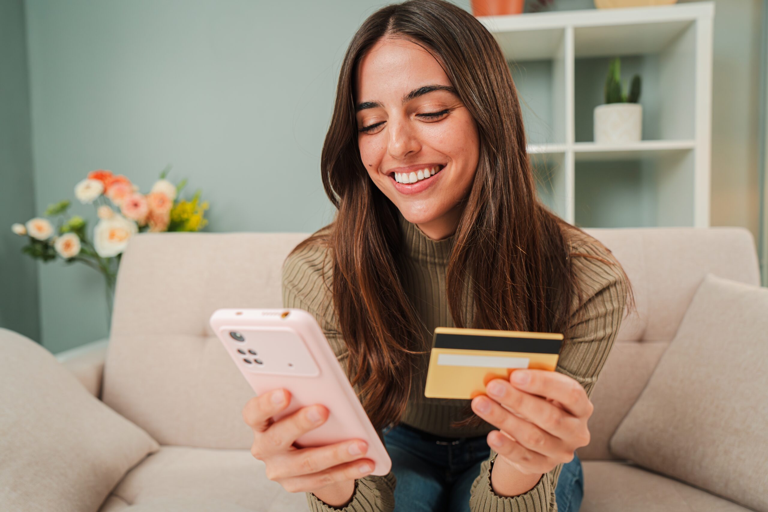 Woman using smartphone and holding credit card