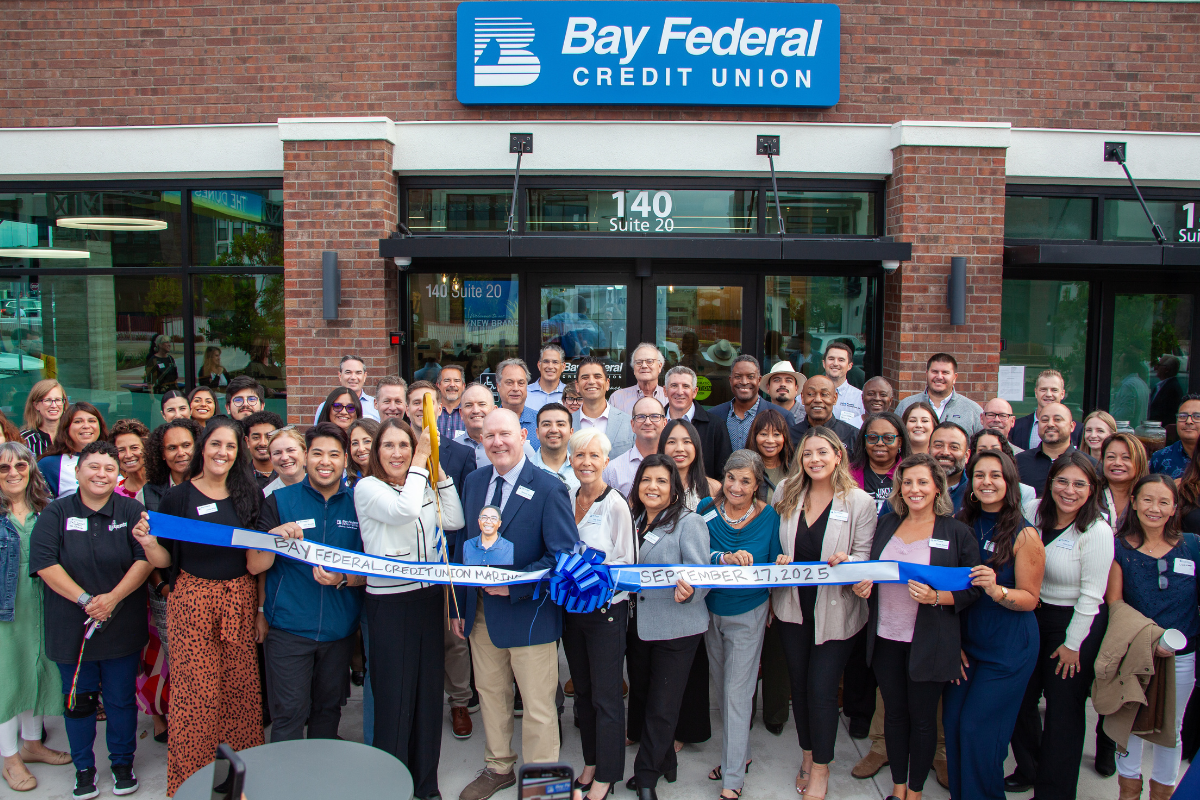 large group of people in front of a new Bay Federal Credit Union branch doing a ribbon cutting