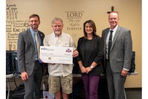 Christina O’Brien, along with members of Robins Financial’s senior leadership team, present check to Kenny Weaver with Meals on Wheels of Houston County.