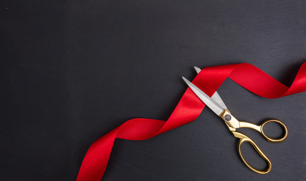 Scissors cutting red ribbon