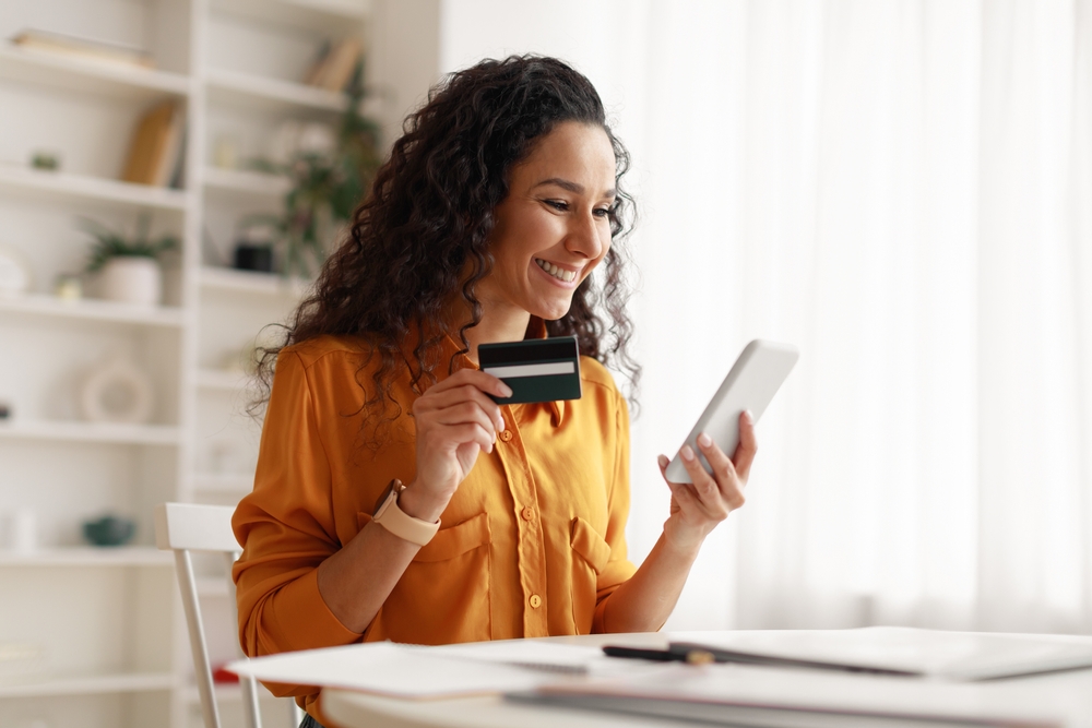 Woman holding smartphone and credit card