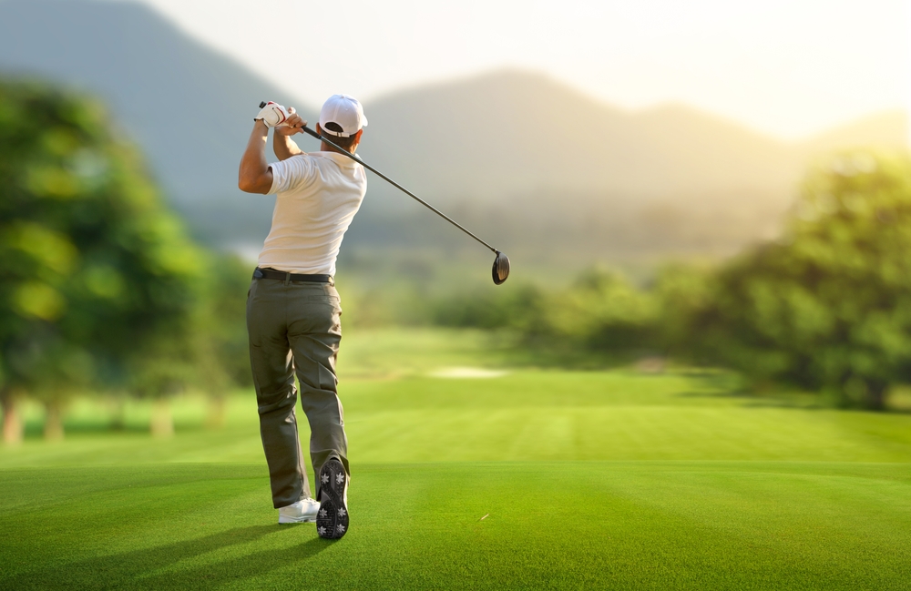 Golf player swinging golf club