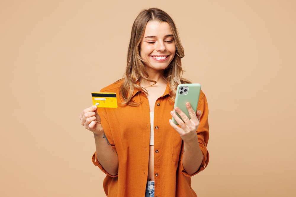 Woman holding smartphone and credit card