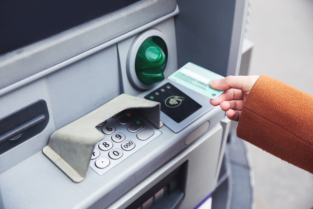 Person holding credit card, about to use ATM