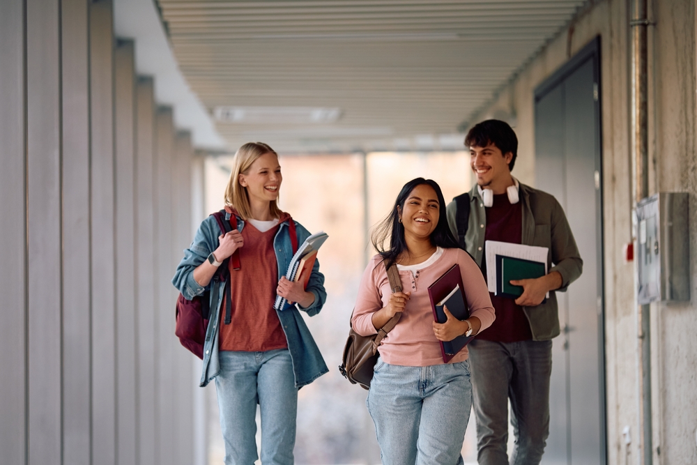 Three college students walking down a hallway
