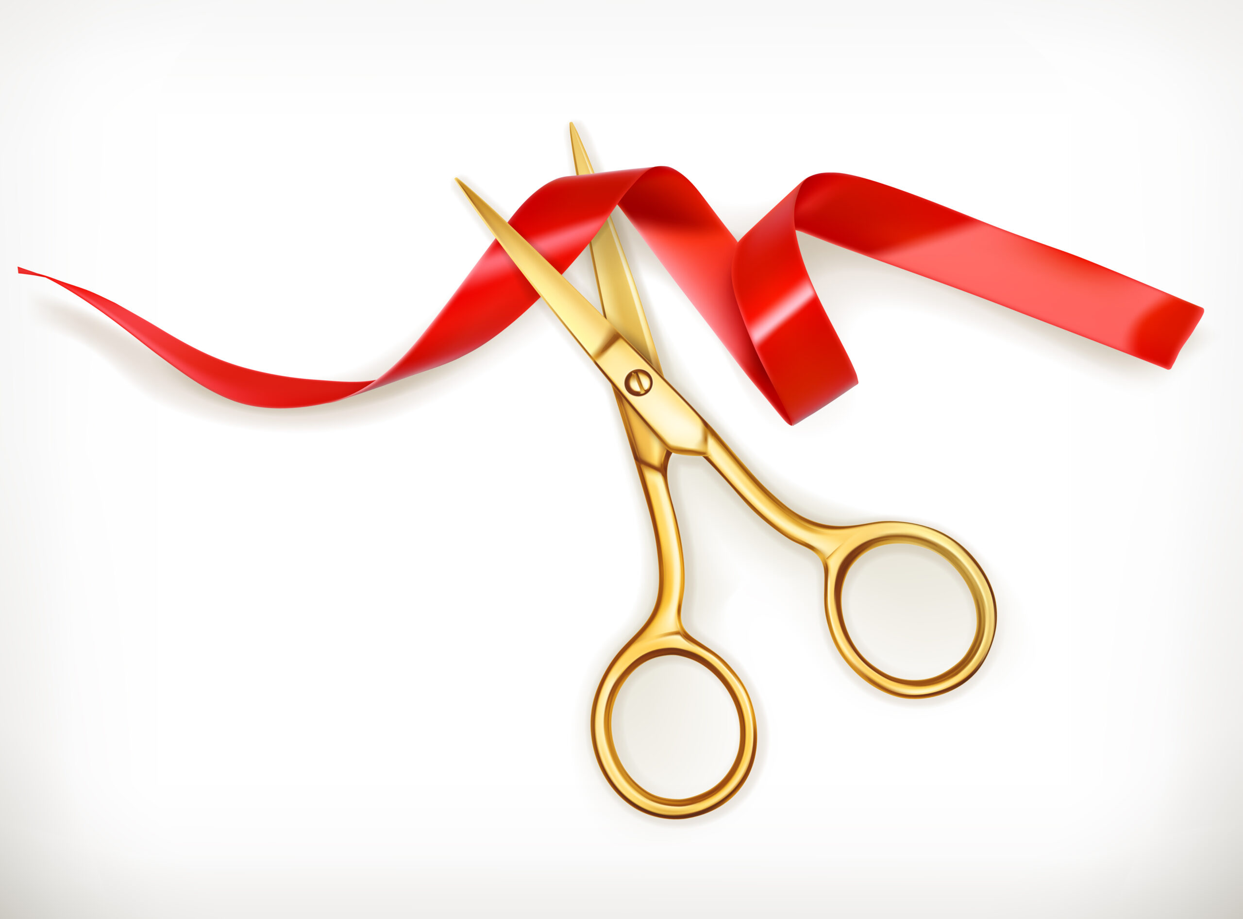 Gold scissors cutting red ribbon
