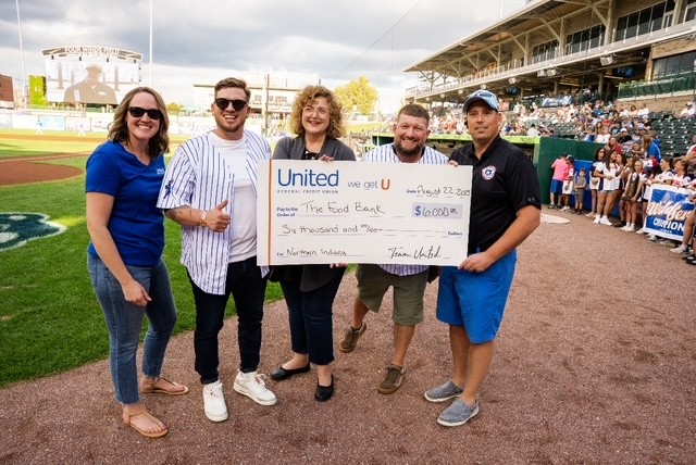 (L to R) Diana Wake (United), Jacob Alexander (United), Marijo Martinec (Food Bank), Ryan Harrington (United) and Joe Hart (Cubs) on the field for the “Strike Out Hunger” check presentation