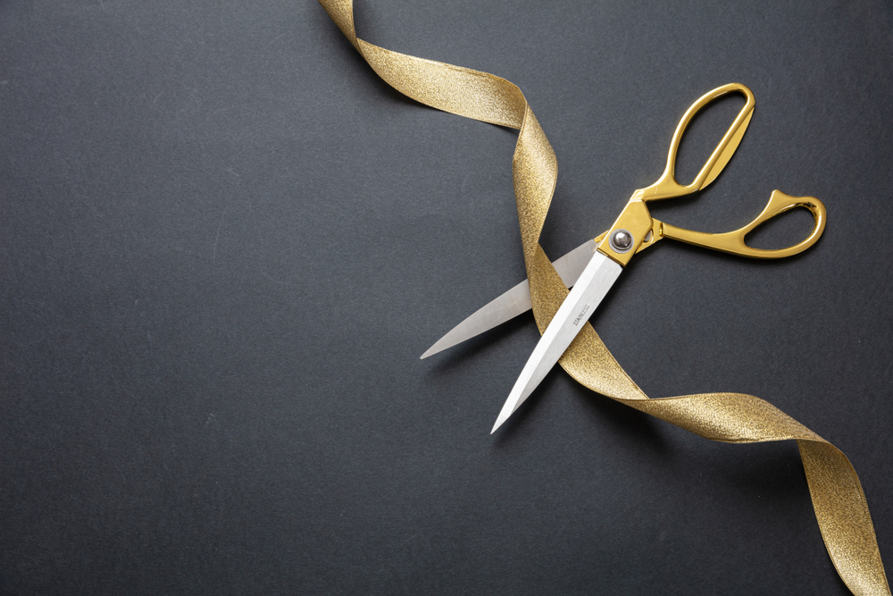 Gold scissors cutting gold ribbon