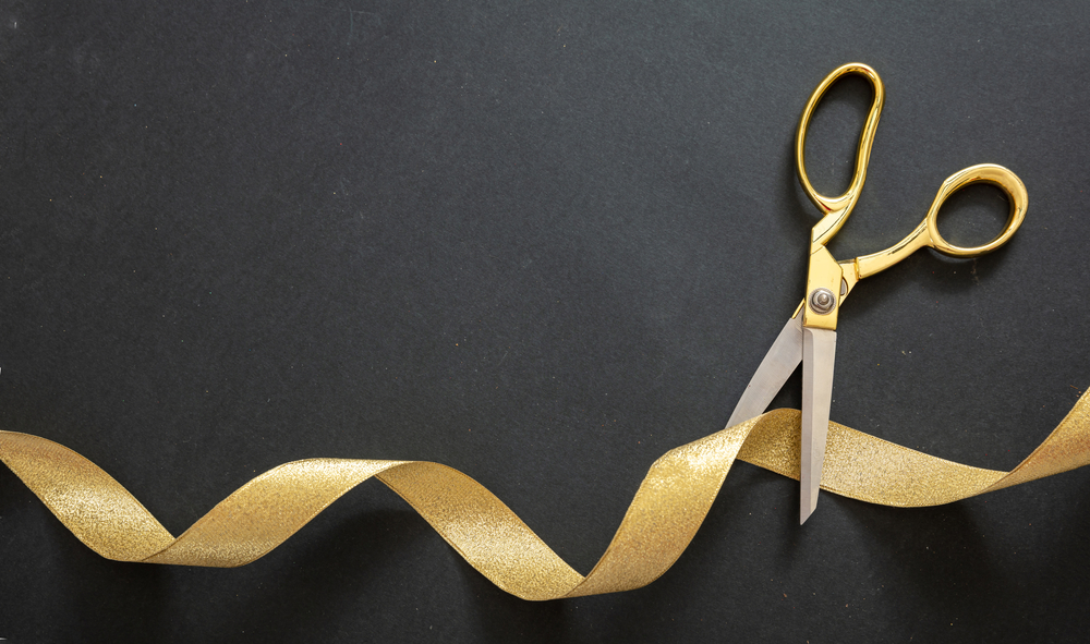 Gold scissors cutting gold ribbon