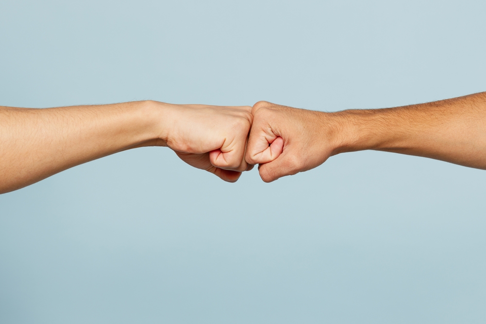 Two people giving each other a fist bump