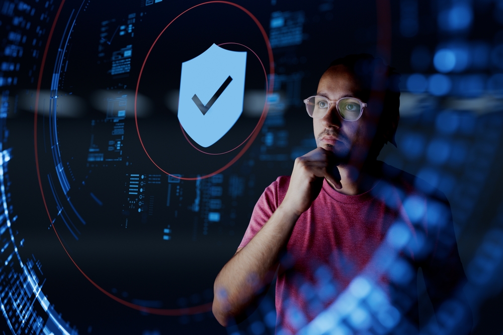 Man looking a digital shield with checkmark in the middle of it