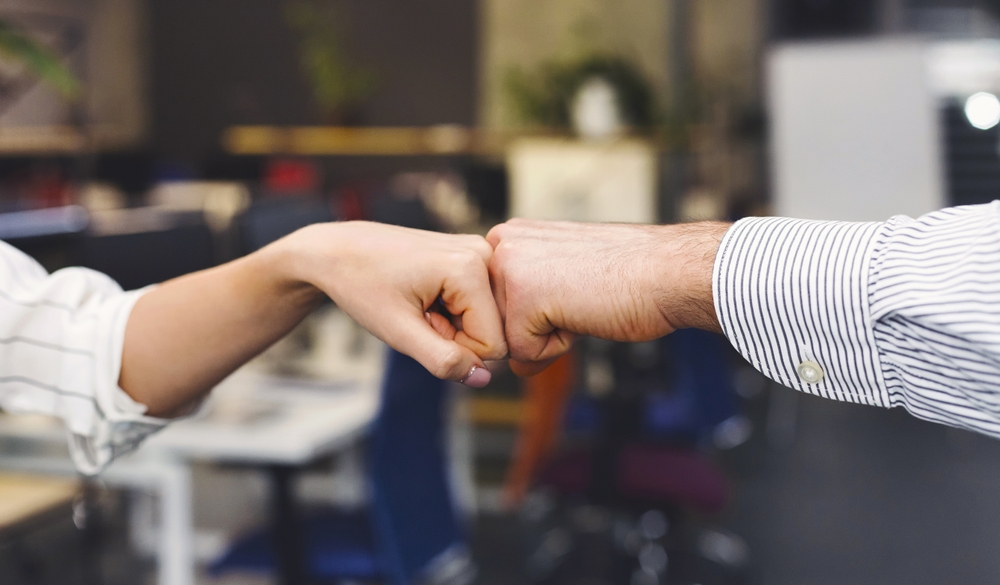 Two businesspeople giving each other a fist bump