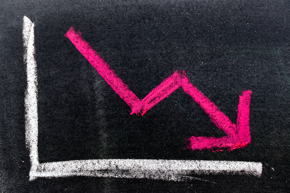 Red arrow going down on graph drawn on chalkboard