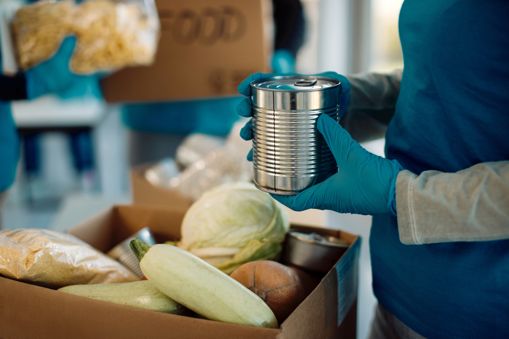 Volunteer filling cardboard box with various kinds of food