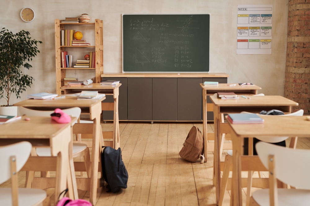 Empty classroom; various schools supplies on desks