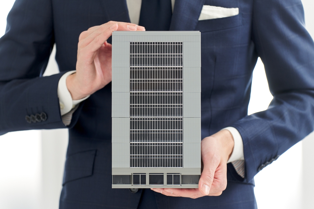 Businessman holding model of office building