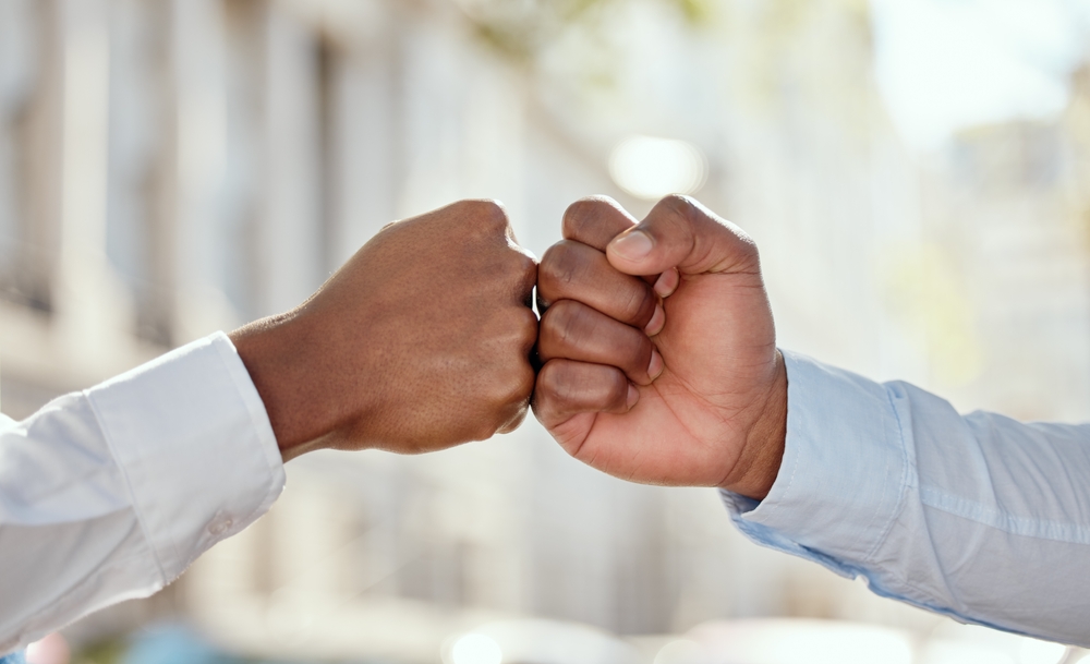 Two businesspeople giving each other a fist bump