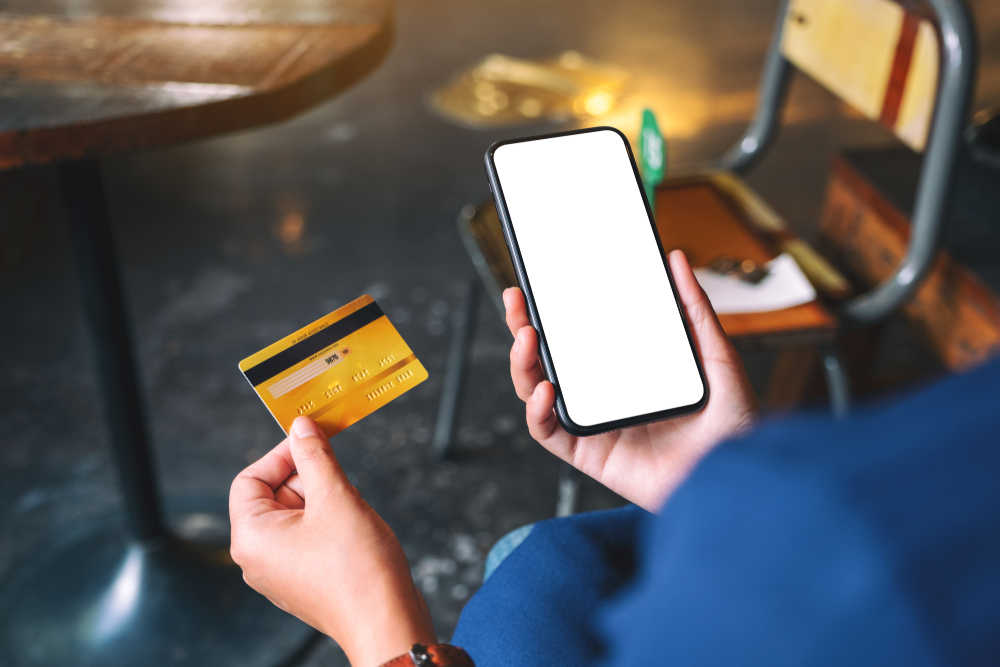 Person holding credit card and smartphone