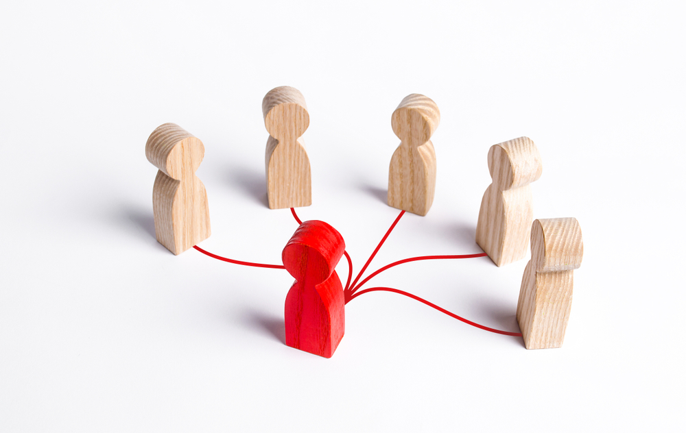 Red wooden figurine with red lines connecting to other wooden figurines