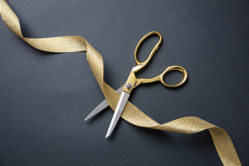 Gold scissors cutting gold ribbon