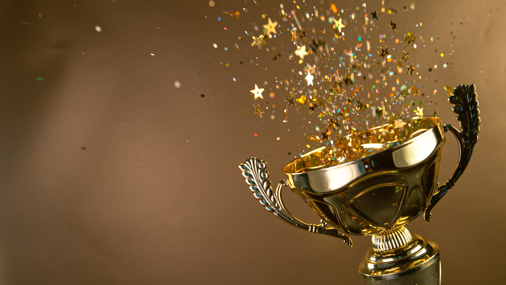 Gold trophy with star-shaped confetti coming out of it