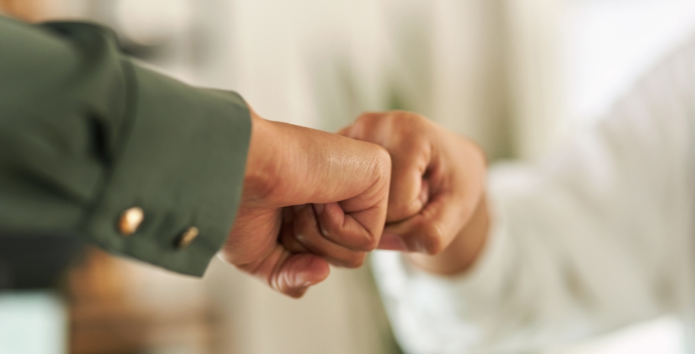 Two businesspeople giving each other a fist bump