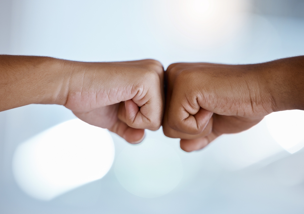 Two people giving each other a fist bump