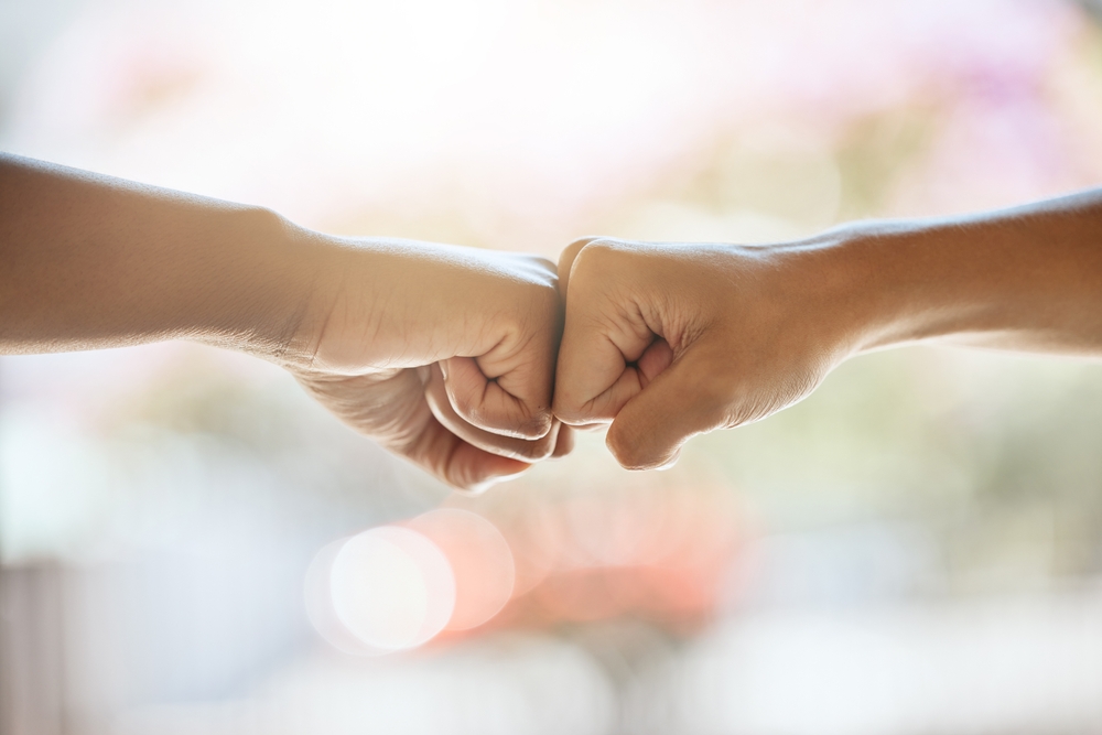 Two people giving each other a fist bump