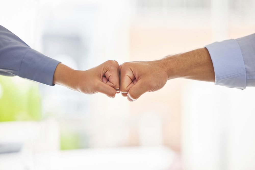 Two businesspeople giving each other a fist bump