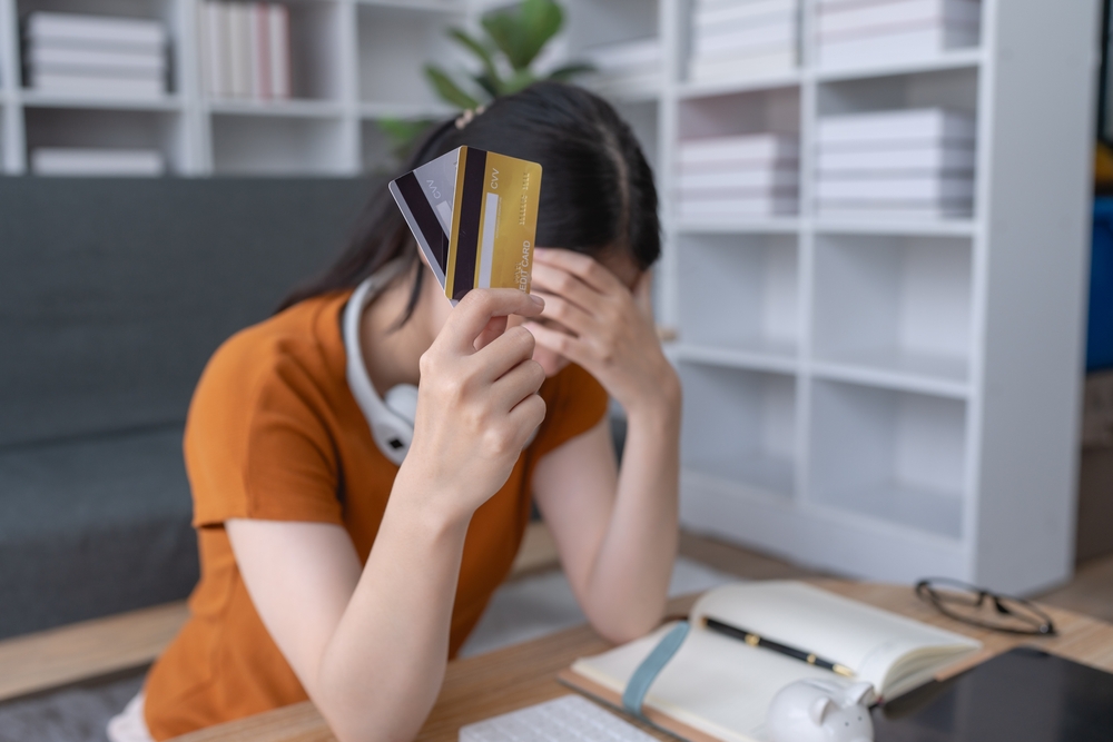 Woman looking stressed while holding two credit cards