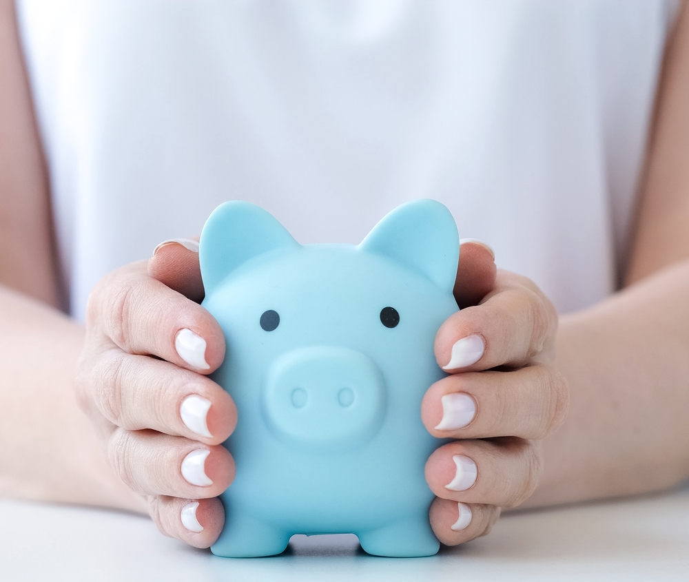 Woman holding blue piggy bank