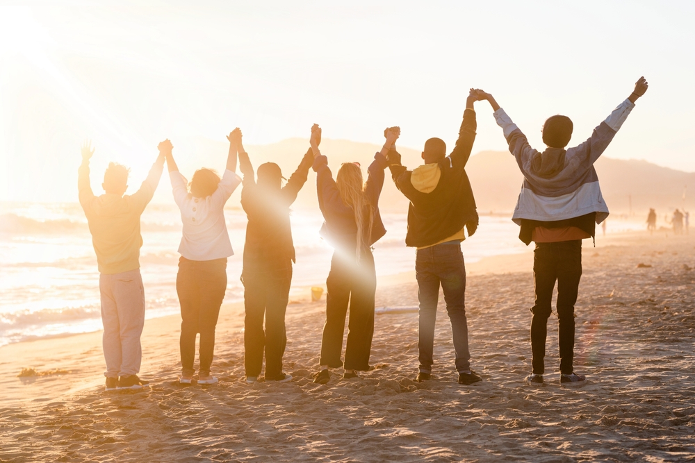 Group of people holding hands on the beach