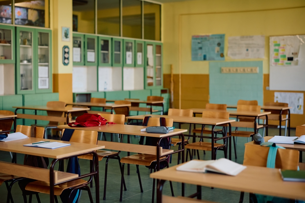 Empty classroom; notebooks and other school supplies on desks