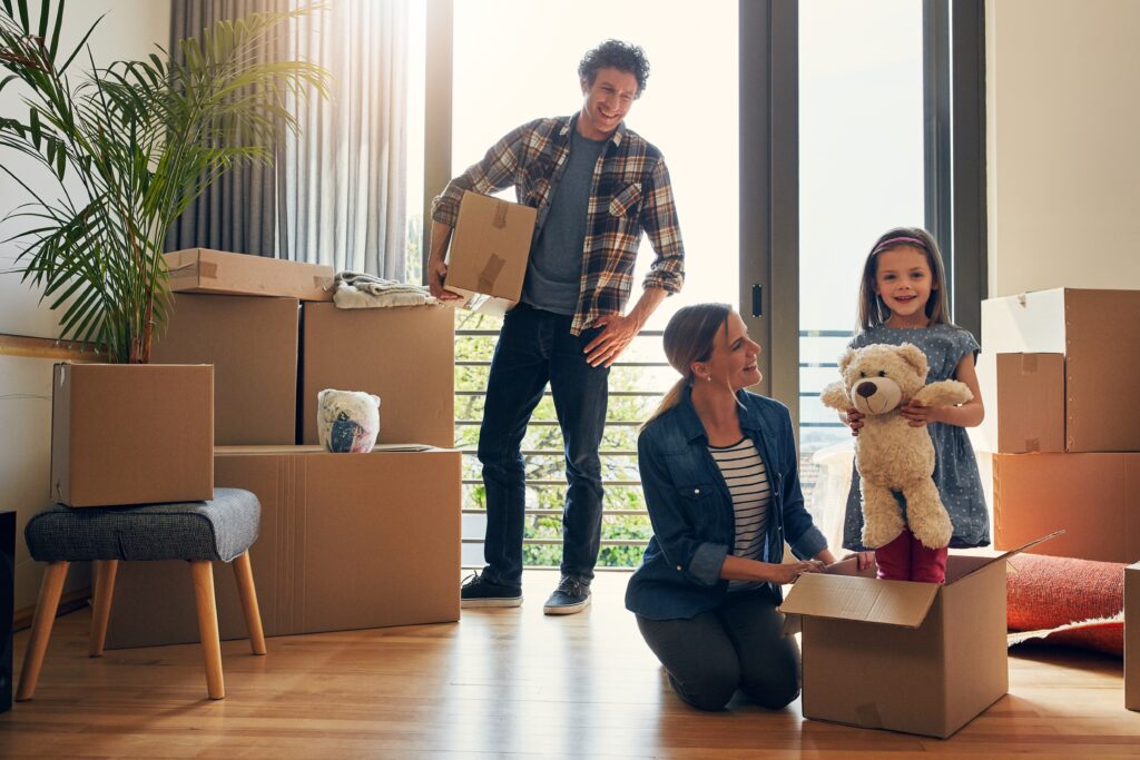 Moving, parents and portrait of child in new home bonding together for family time with teddy bear. Happy, mortgage and girl kid play with mom and dad for fun and unpacking cardboard boxes for house.