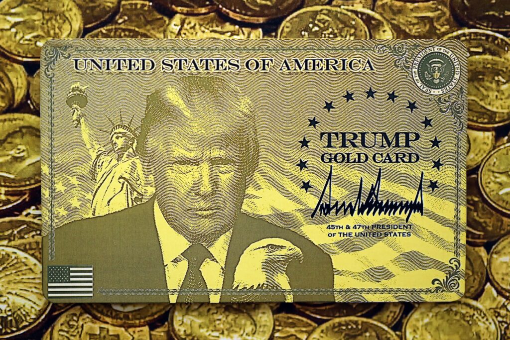 KYIV, UKRAINE - DECEMBER 13, 2025 Trump gold card souvenir on shiny golden coins background print close up
