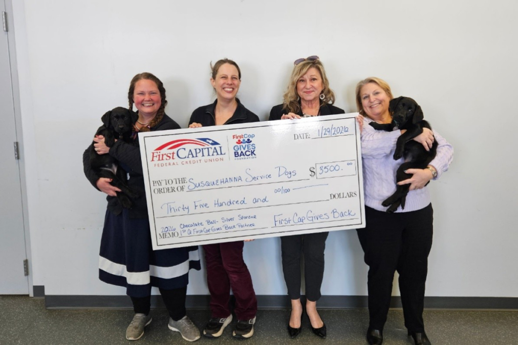 First Capital FCU presenting a big check to Susquehanna Service Dogs for $3500 4 people holding big check