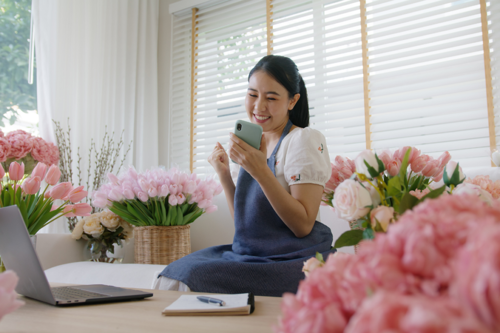 SME owner modern small flower shop work at home office happy smile fist up read text e-mail message banking lending money online. Young adult woman asia people joy seller job in sale order good news.