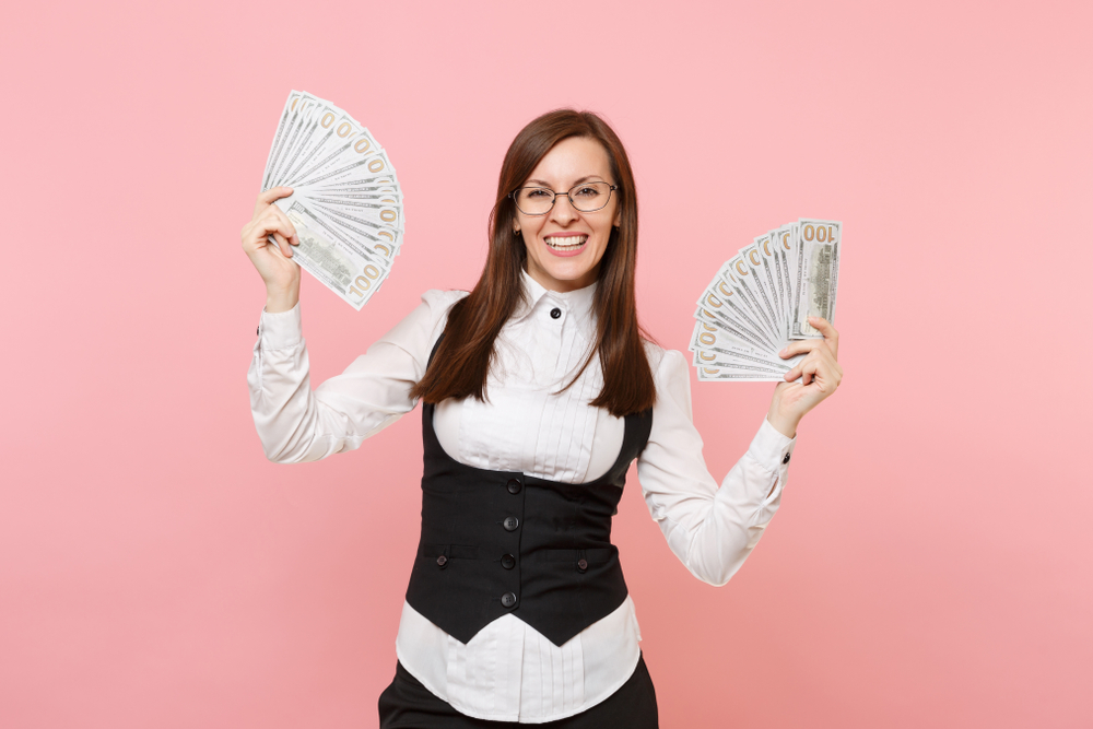 Woman holding $100 bills in both hands