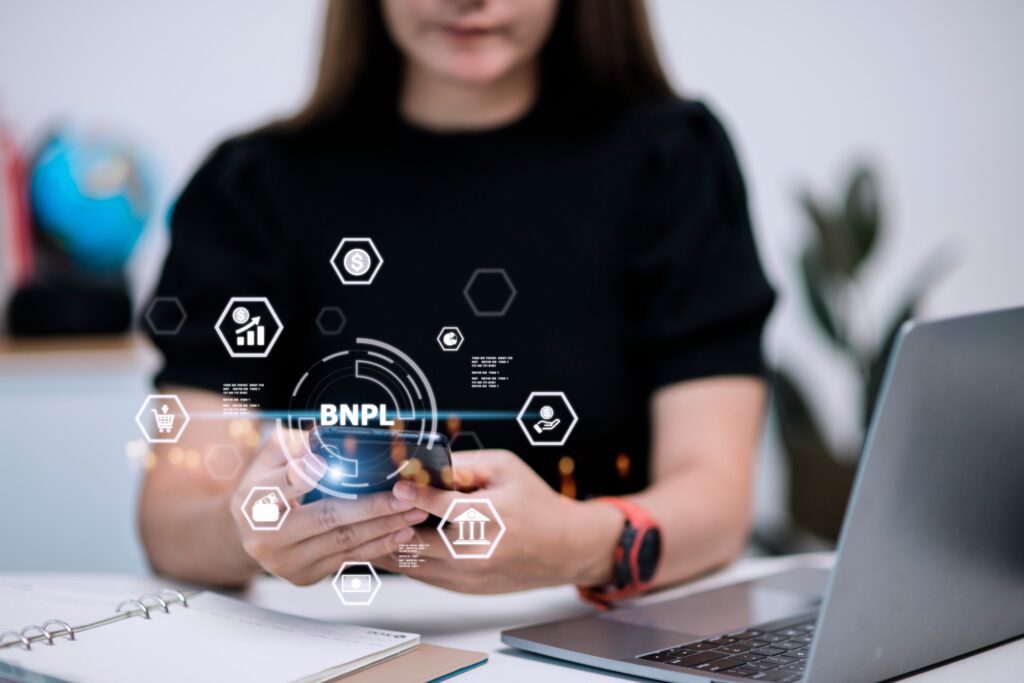 Women holding a smartphone with icons of BNPL with online shopping icons technology. BNPL Buy now pay later online shopping concept.