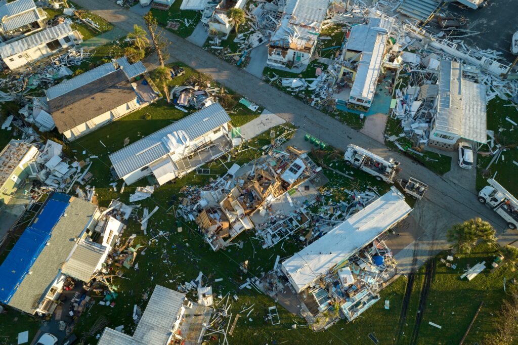 Consequences of natural disaster in Florida, USA. Aerial view of heavily damaged by hurricane Ian houses in mobile home residential area