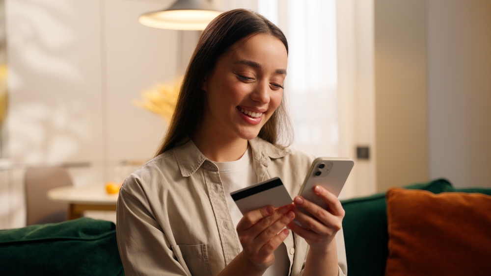 Woman holding credit card and smartphone