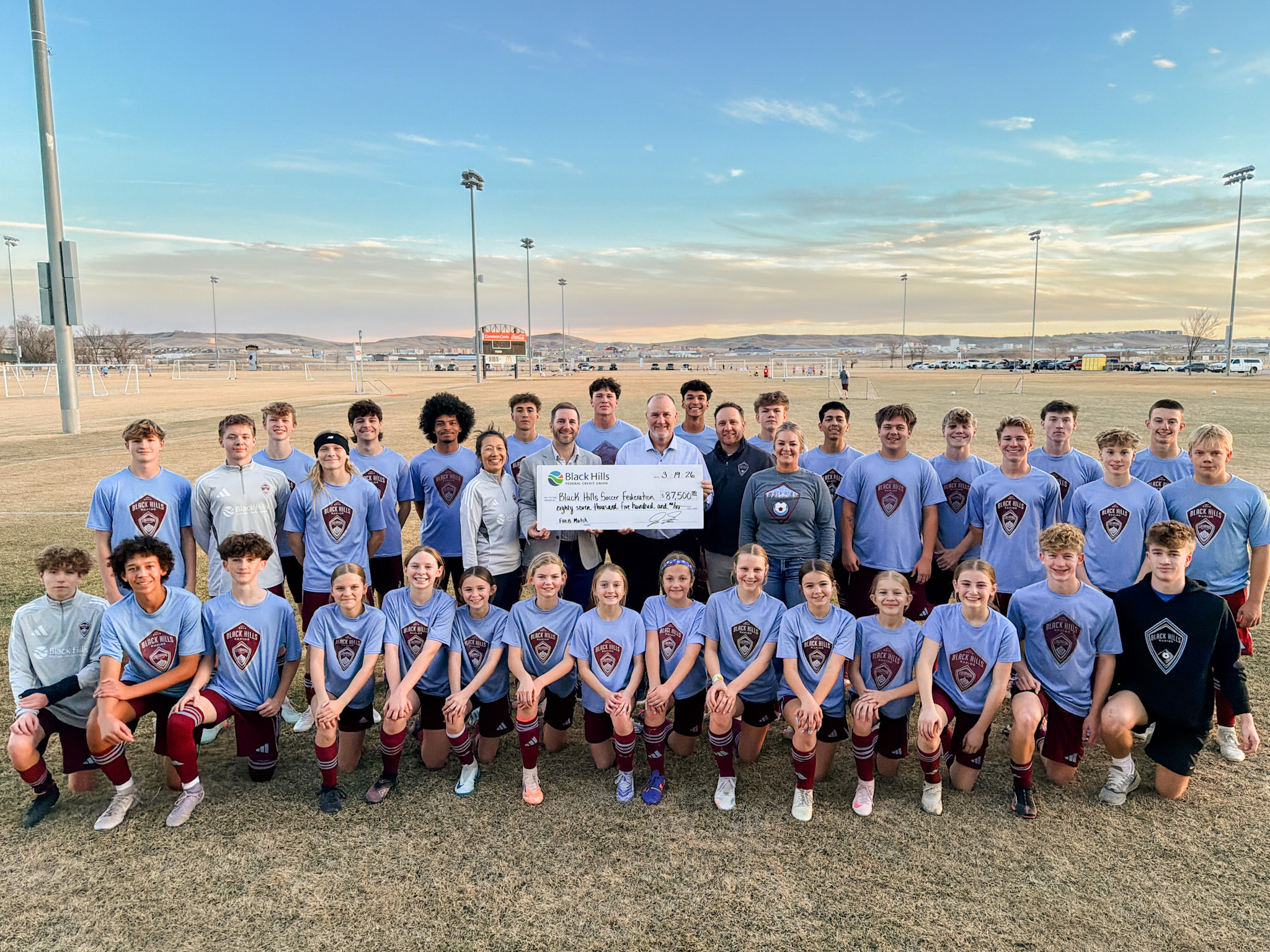 Black Hills Soccer Federation (facility upgrades + community access) receiving a check for $87,500 with a youth soccer team posing for the big check photo